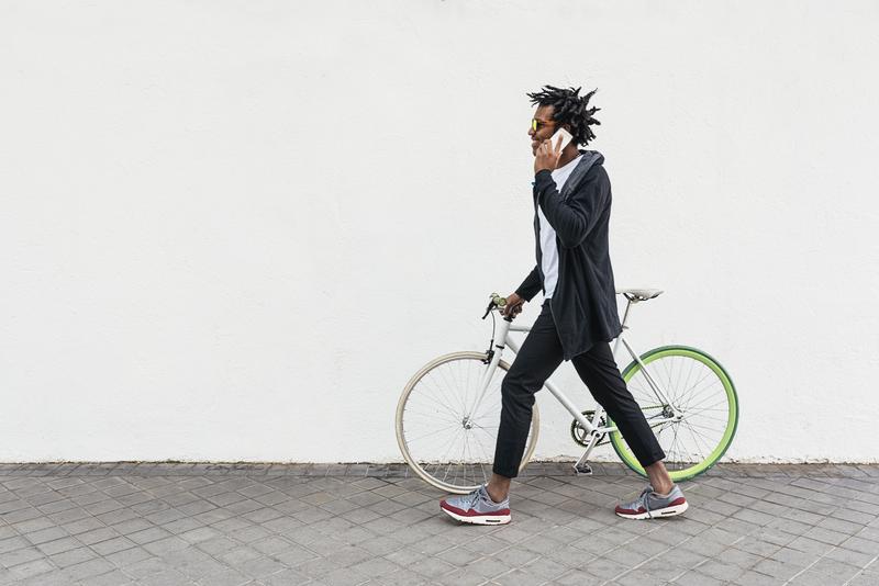 一个年轻人一边骑自行车一边打电话的照片